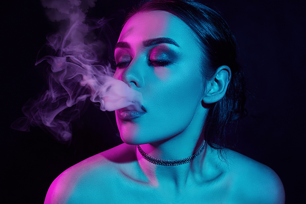 Glamour seductive gorgeous brunette woman smoking electronic cigarette